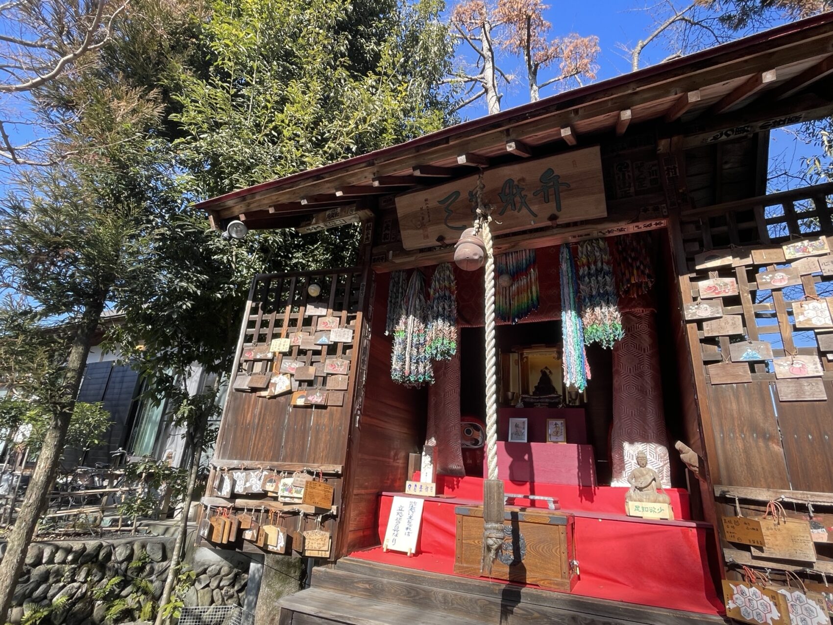 東京都青梅市の金剛山玉泉寺の境内。手入れされた庭園と古木が調和し、秋の光が差し込む穏やかな風景。能登半島地震チャリティーコンサートの会場となる歴史あるお寺の美しい情景。